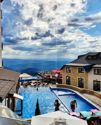 a large swimming pool with a view of the mountains at N-delux apartman in Kopaonik