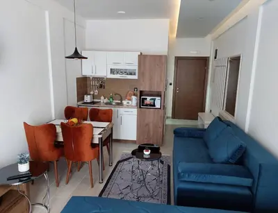 a living room with a blue couch and a kitchen at N-delux apartman in Kopaonik