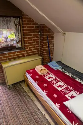 a room with a bed with a red blanket at Zimska idila in Crni Vrh