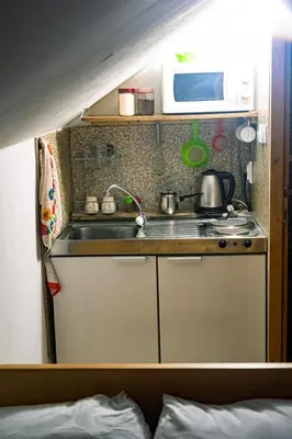 a small kitchen with a sink and a microwave at Zimska idila in Crni Vrh