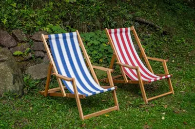 two beach chairs sitting in the grass at Zimska idila in Crni Vrh