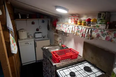 a small kitchen with a sink and a red basket at Zimska idila in Crni Vrh