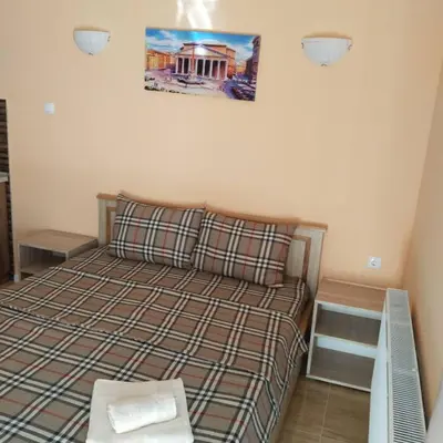 a small bedroom with a bed and a picture on the wall at Vila Suzana in Vrnjačka Banja