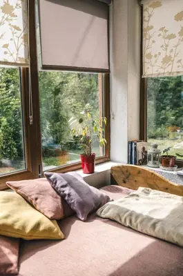 a bed sitting in a room with a window at Zeleni svet 2 in Crni Vrh