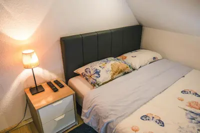 a small bedroom with a bed and a nightstand with a lamp at Zeleni svet 2 in Crni Vrh