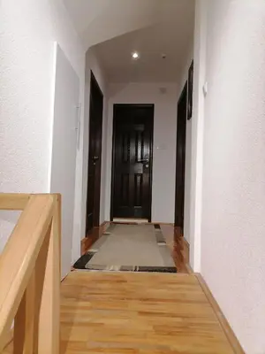 a hallway with white walls and wooden floors and a door at Zeleni svet 2 in Crni Vrh