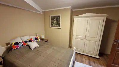 a bedroom with a large bed and a white cabinet at Ski House in Kopaonik