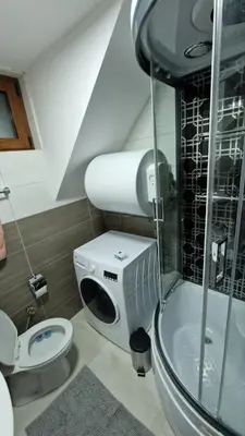 a bathroom with a toilet and a glass shower at Ski House in Kopaonik