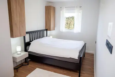 a small bedroom with a bed and a window at Mountain Chalet Kopaonik in Kopaonik