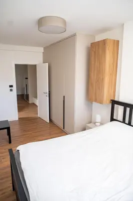 a bedroom with a white bed and a wooden cabinet at Mountain Chalet Kopaonik in Kopaonik
