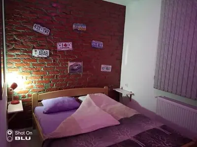 a bedroom with a brick wall and a bed at Apartman Ivanovic 6 Sokobanja in Soko Banja
