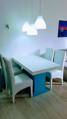 a table and chairs in a room with a blue wall at Apartman Ivanovic 6 Sokobanja in Soko Banja