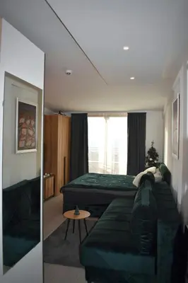 a bedroom with a green couch and a bed at Eagle View Milmari N81 in Kopaonik