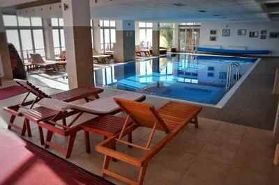 a large swimming pool with chairs and tables in a building at Eagle View Milmari N81 in Kopaonik