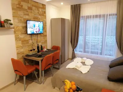 a living room with a dining room table and a television at Milmari Future Gold Apartmani Kopaonik in Kopaonik
