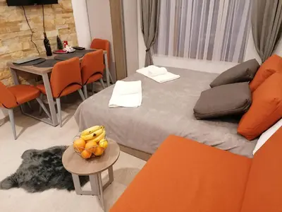 a room with a bed and a table with oranges on it at Milmari Future Gold Apartmani Kopaonik in Kopaonik