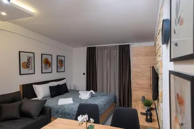 a bedroom with a bed and a living room at Milmari - Apartman N85 in Kopaonik