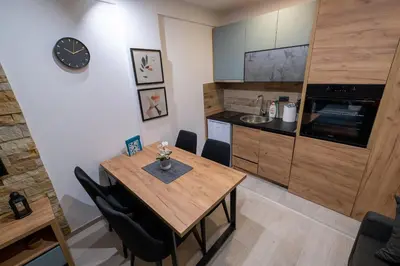 a kitchen with a wooden table and a dining room at Milmari - Apartman N85 in Kopaonik