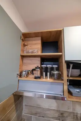 a kitchen with wooden shelves with pots and pans at Milmari - Apartman N85 in Kopaonik