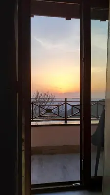 a view of the sunset from a room with a window at Milmari - Apartman N85 in Kopaonik