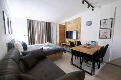 a room with a bed and a table and a couch at Milmari - Apartman N85 in Kopaonik
