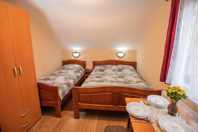 two twin beds in a small room with a table at Vila Nada in Crni Vrh