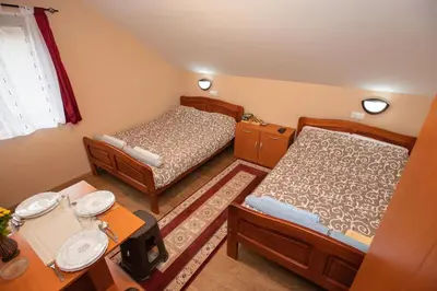a small bedroom with two beds and a table at Vila Nada in Crni Vrh