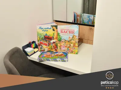 a table with a book and some toys on it at Apartman PETICA KOP A8 Kopaonik in Kopaonik