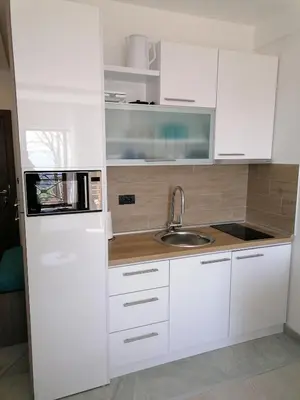 a white kitchen with a sink and a microwave at Ivkovic spa Milmari N16 in Kopaonik