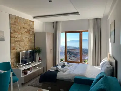 a bedroom with a large bed and a large window at Ivkovic spa Milmari N16 in Kopaonik