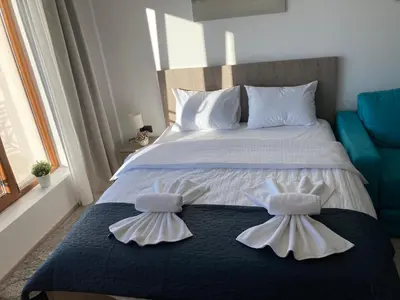 a bedroom with a bed with two white towels on it at Ivkovic spa Milmari N16 in Kopaonik