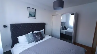 a bedroom with a large bed and a mirror at Relax apartment Kopaonik in Kopaonik