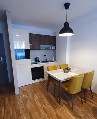 a kitchen and dining room with a table and chairs at Relax apartment Kopaonik in Kopaonik