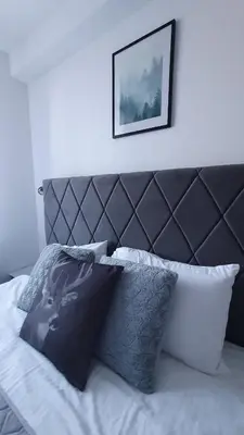 a bed with a black and white headboard and pillows at Relax apartment Kopaonik in Kopaonik