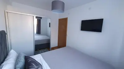 a bedroom with a bed with a mirror and a television at Relax apartment Kopaonik in Kopaonik