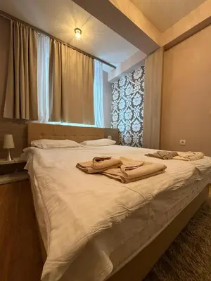 a bedroom with a large white bed with a window at Mujen Lux Tutic - Free Spa & Wellness in Kopaonik