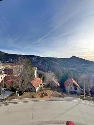 an empty street in a small town with a mountain at Mujen Lux Tutic - Free Spa & Wellness in Kopaonik