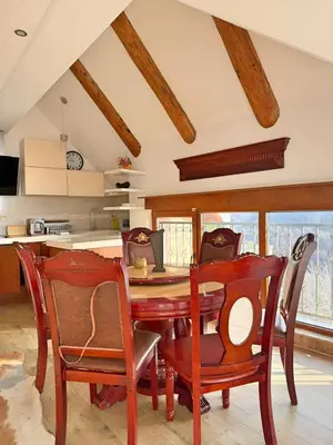 a kitchen with a wooden table and chairs at Mujen Lux Tutic - Free Spa & Wellness in Kopaonik