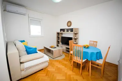 a living room with a table and a couch at Apartman Nikolina in Vrnjačka Banja