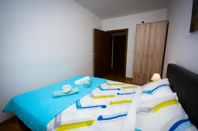 a bedroom with a bed with a blue comforter at Apartman Nikolina in Vrnjačka Banja