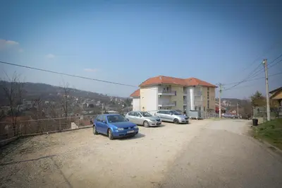 a group of three cars parked in a parking lot at Apartman Nikolina in Vrnjačka Banja