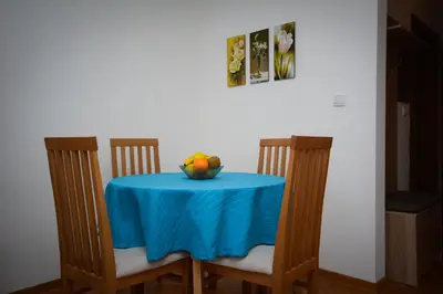 a table with a blue table cloth and a bowl of fruit at Apartman Nikolina in Vrnjačka Banja