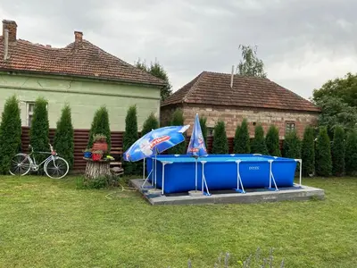 a blue table with an umbrella in a yard at Seosko turističko domaćinstvo Stojković in Aleksinac