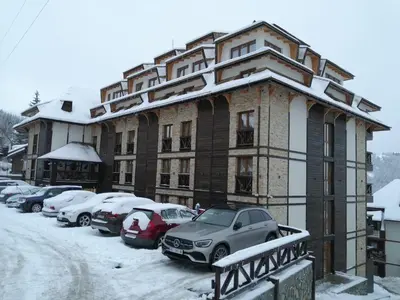 a large building with cars parked in a parking lot at Apart Hotel & spa Zoned II, Kopaonik, apartman Lukač - special benifit Children up to 17 of age accompanied by two adutls staj for free! FREE PARKING! in Kopaonik