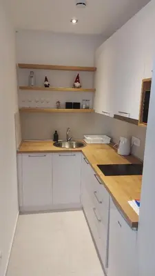 a kitchen with white cabinets and a sink at Apartmani Šišarka in Kopaonik