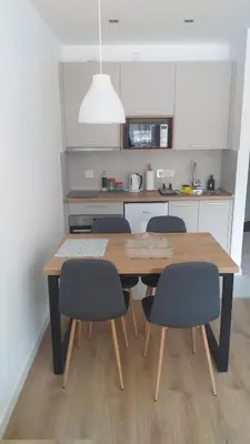 a kitchen with a wooden table and chairs in a kitchen at Apartmani Šišarka in Kopaonik