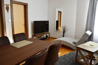 a living room with a table and a flat screen tv at Ski Adventure - Brzeće, Kopaonik in Kopaonik