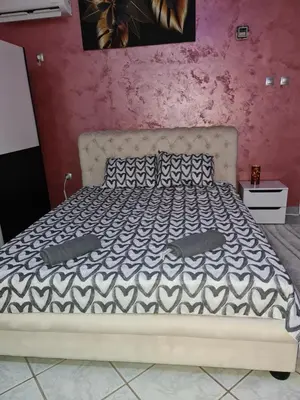 a bed in a bedroom with a pink wall at Apartman -HARMONY- in Paraćin