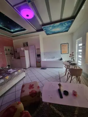 a living room with a bed and a table and a kitchen at Apartman -HARMONY- in Paraćin