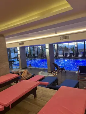 a large swimming pool with red benches in a building at Apartman Enjoy N82 Milmari&spa in Kopaonik